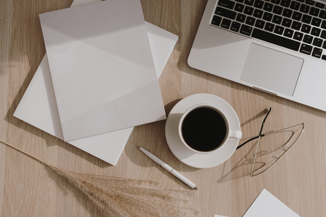 Laptop, Coffee, and Notebooks on Wooden Table